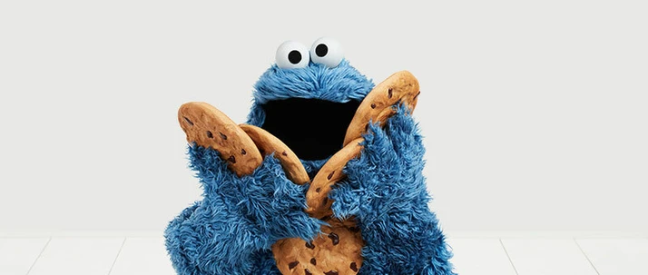 Cookie Monster holding five chocolate chip cookies